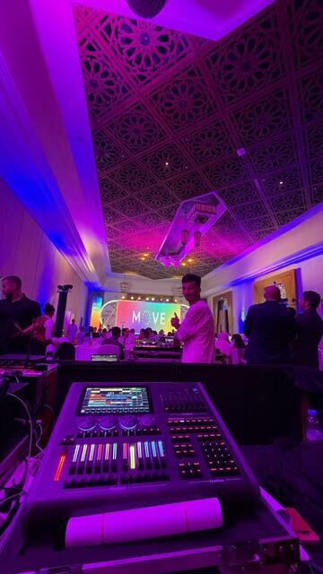 Console de mixage devant une salle de réception éclairée pour une soirée